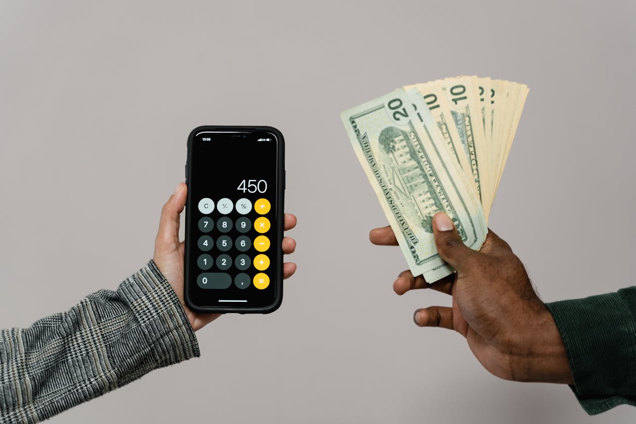 Person berechnet Geld am Taschenrechner - Bankroll Management und Einsatzplanung